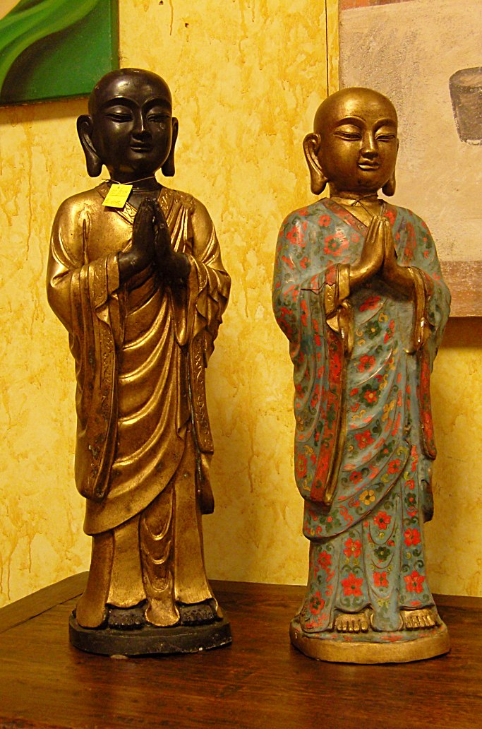 Buddha in ceramica , in piedi con mani giunte raffigura il gesto di adorazione e di saluto.