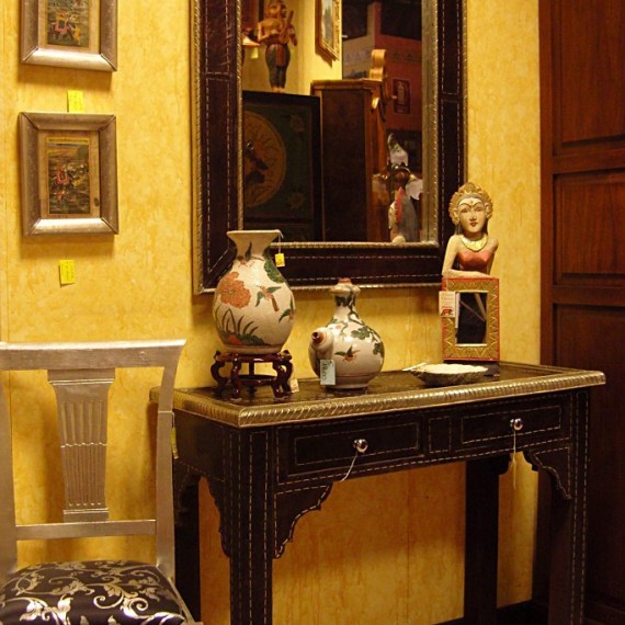 Consolle e specchio Indiano, in legno foderato di pelle color testa di moro e bordi in lamina argentata.