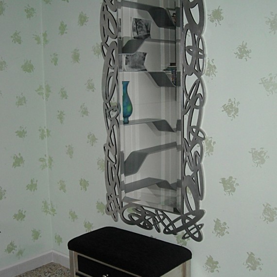 Specchio con cornice traforata e rifinita foglia argento.